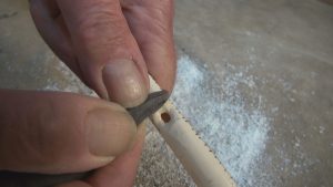 Scraping the finger holes with a burin